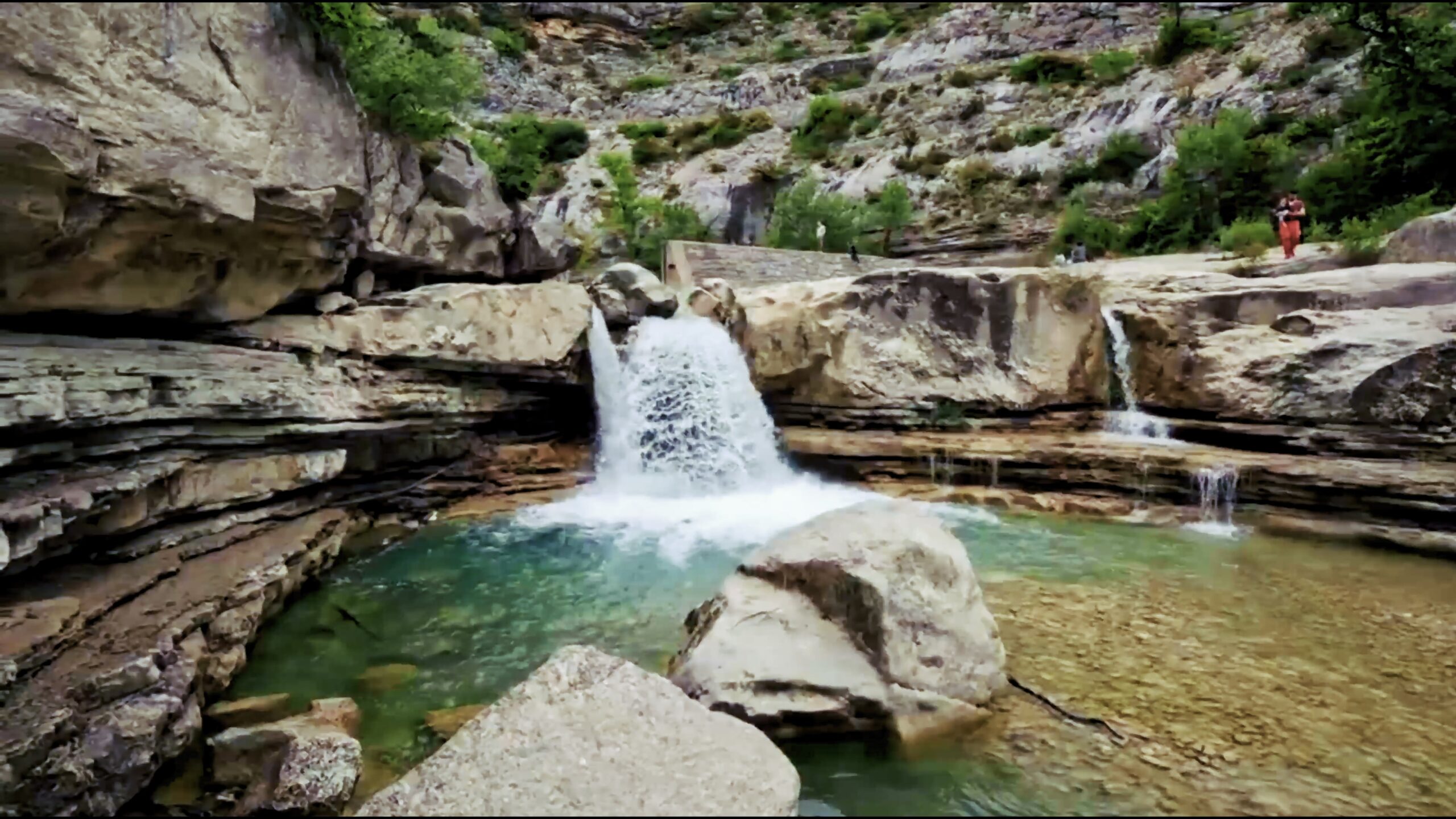 Cascade qui se jette dans un bassin naturel entre des rochers
